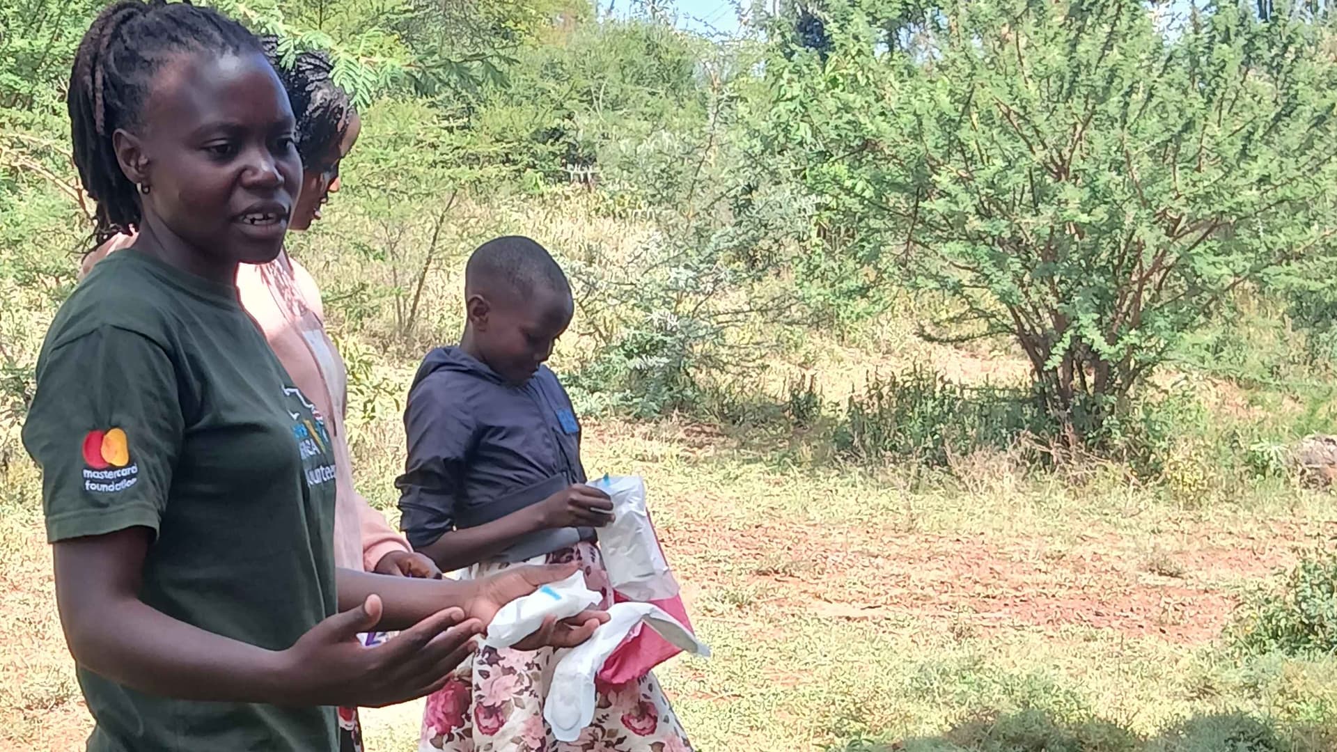 A participant of the workshops being helped to demonstrate proper use of a sanitary towels
