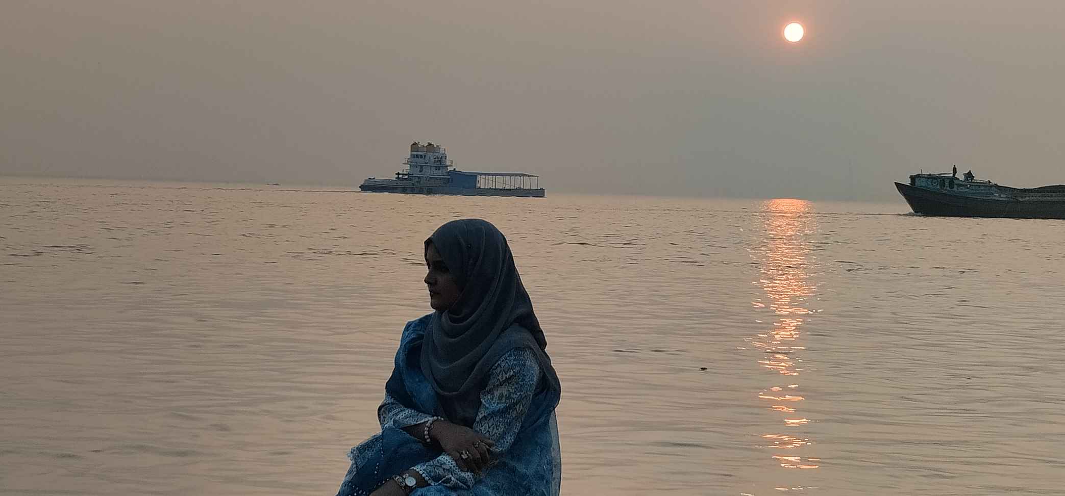 A woman sitting peacefully outside.