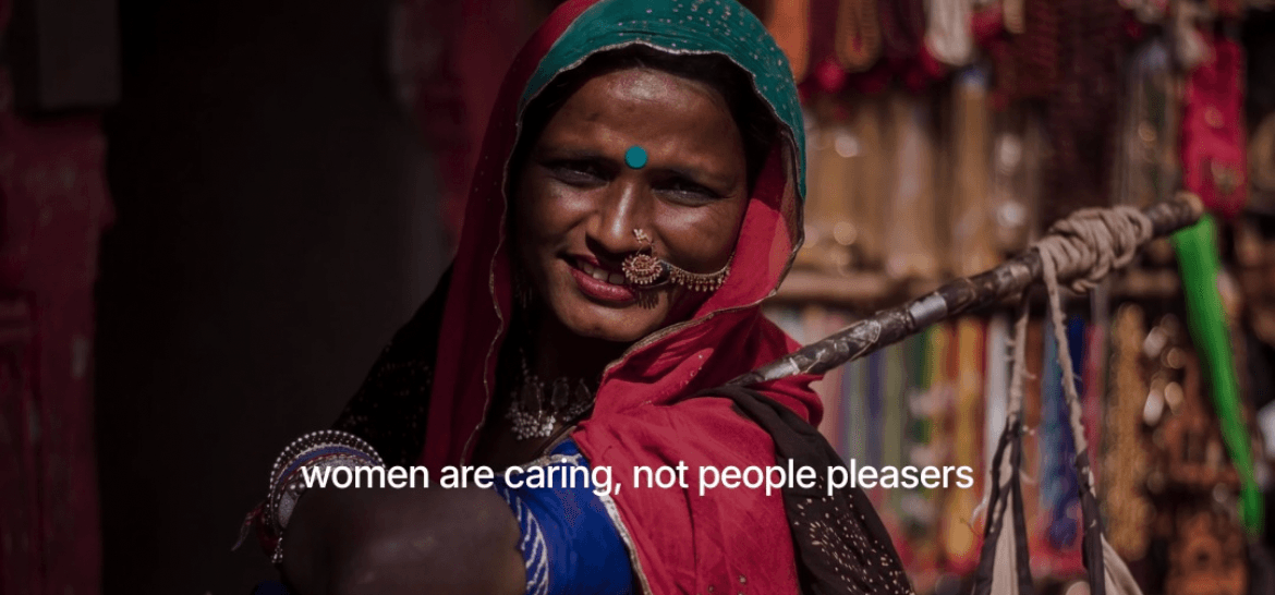 A woman wearing a traditional headscarf looks toward the camera with a serious and emotional expression